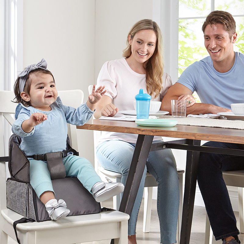 Toddler sitting on the booster seat at the table
