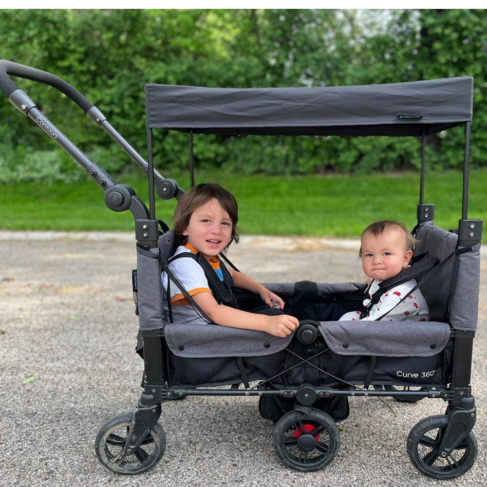 siblings sitting in stroller wagon